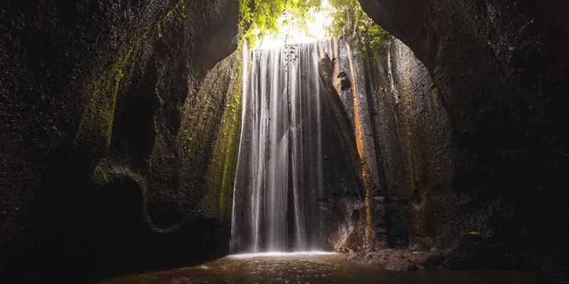 Stunning light rays at Tukad Cepung Waterfall near Ubud.