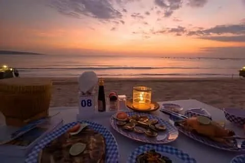 Romantic seafood dinner at Jimbaran Beach during twilight.