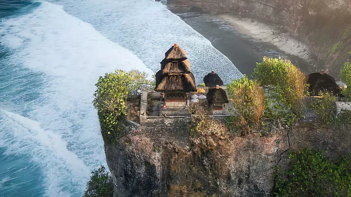 Uluwatu Temple perched on a cliff during a golden sunset.
